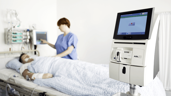 Hospital situation. Nurse with patient in bed. ABL80 blood gas analyzer from Radiometer 