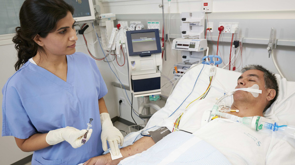 Hospital situation - nurse with patient, preparing blood gas sample for analyzing