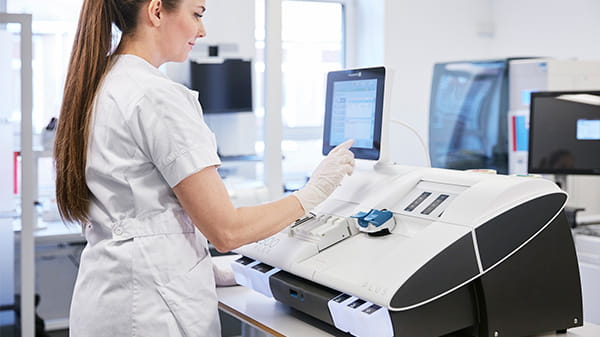 Nurse stading in front of the ABL800 fLEX blood gas analyser