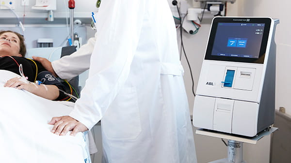Patient and doctor next to the ABL9 blood gas analyzer from Radiometer